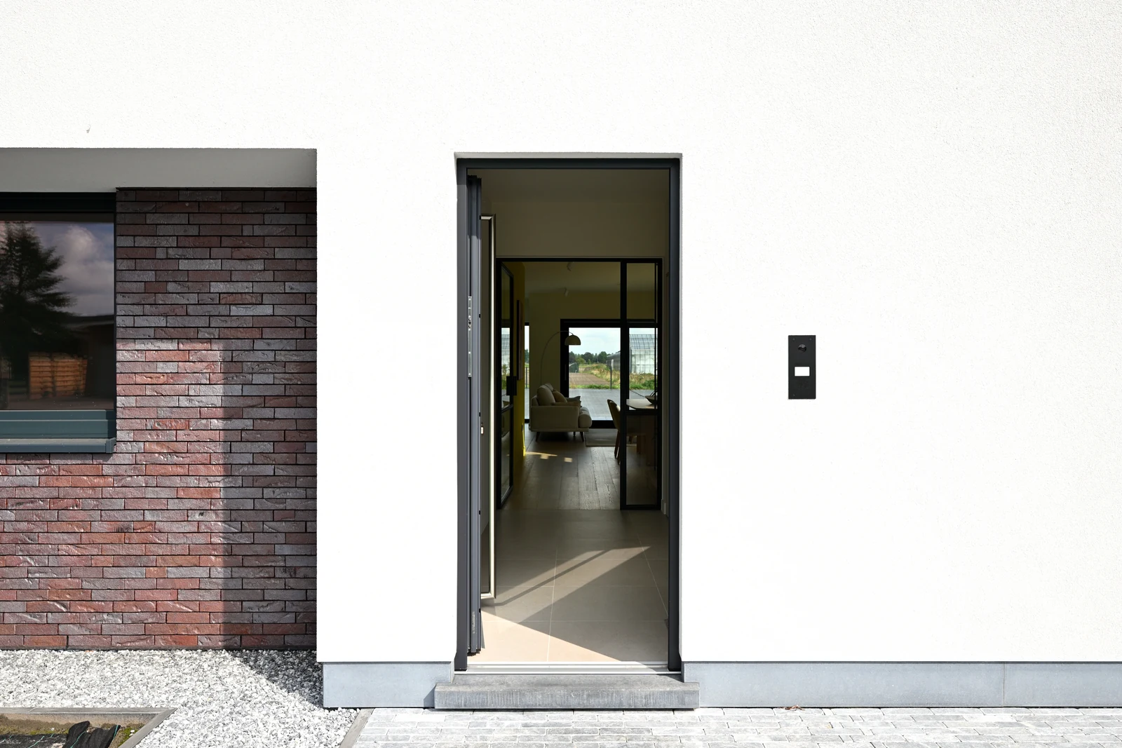 Openstaande voordeur met zicht door de woning naar de tuin